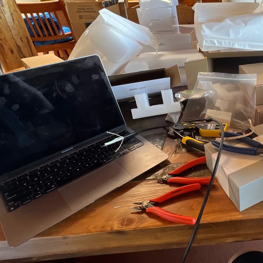 Laptop, networking equipment, and cable tools laid out for hands-on IT work